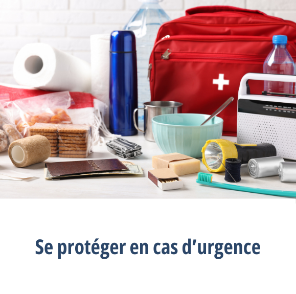 Une table remplie de fournitures d’urgence, comme une trousse de premiers soins, des aliments non périssables, une lampe de poche et une radio, ainsi que le bouton « Protégez-vous en cas d’urgence »